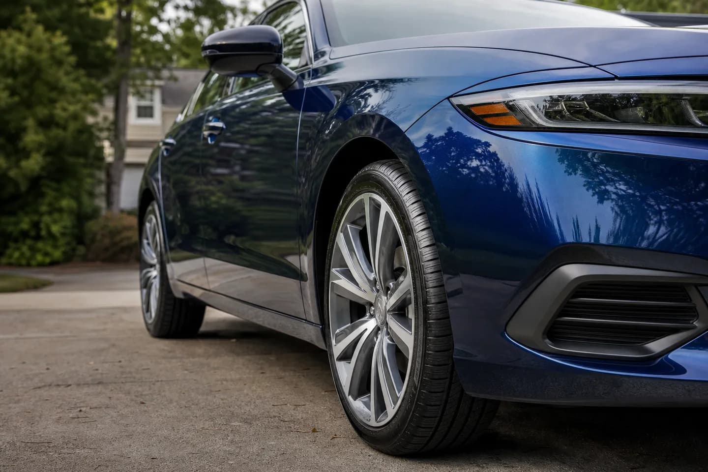 Illustrative deep-blue sedan with polished paint and a clean front wheel after detailing